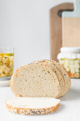slices of artisan bread loaf, sesame coated bread slices on a marble tray, sandwich bread slices on a tray