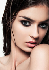 Beautiful woman with make up and wet hair on white background with smokey eyes and red lips