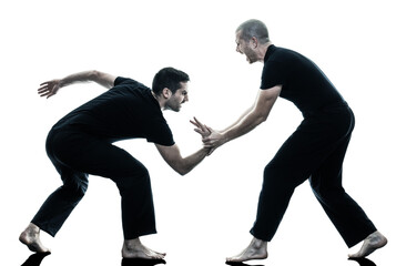 two caucasian men krav maga fighters fighting isolated silhouette on white background