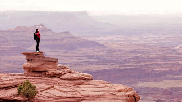 Asian woman hiking through the amazing landscape near Moab Utah, USA.