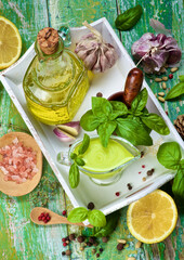 Ripe Raw Ingredients and Freshly Made Creamy Pesto Sauce in Glass Gravy Boat in White Wooden Tray....