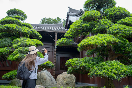 Asian tourist, cute woman with long hair are traveling in Hong Kong along with map and her camera with fun on her holiday, A temple Nan Lian Garden in Hong Kong, concept travel.