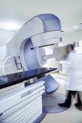 X-ray linear accelerator tomography machine with blurred doctors figure in hospital.