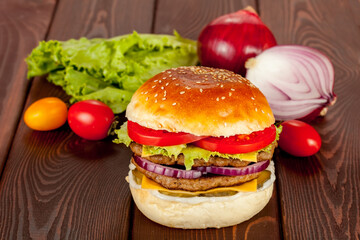 Double beef burger with ingridients on wood background