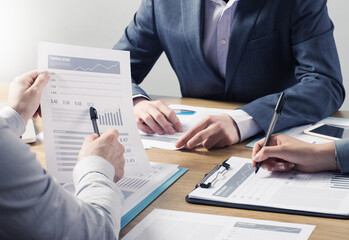 Financial service professional team at work, hands close with business reports and paperwork