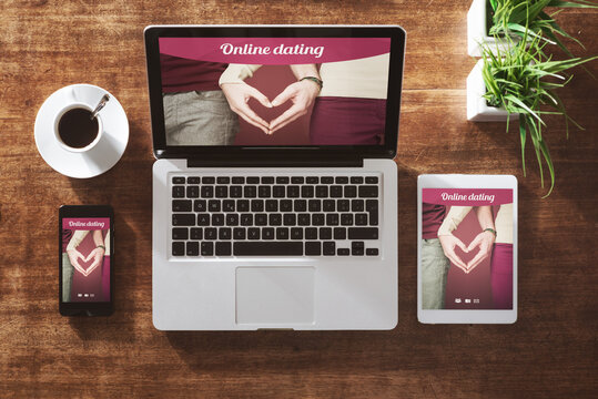 Online dating website on a laptop display, hardwood desktop on background