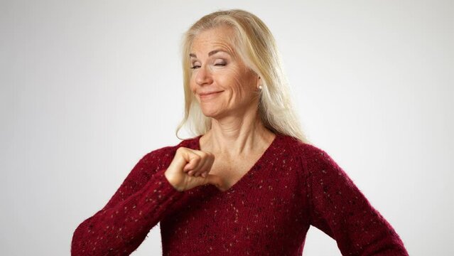 Portrait of confident elderly gray-haired blonde woman lady 50s years old point fingers on herself show thumbs up like gesture isolated on solid white background studio