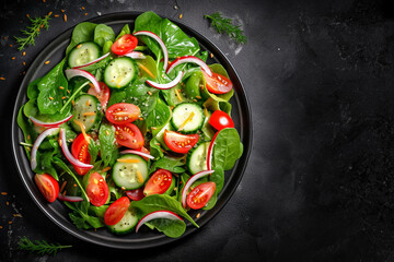 Healthy green salad with fresh tomato, cucumber, red onion and lettuce in bowl on dark stone background. Top view. generative ai.