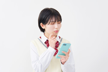 スマホを持って悩む女子高生　白背景