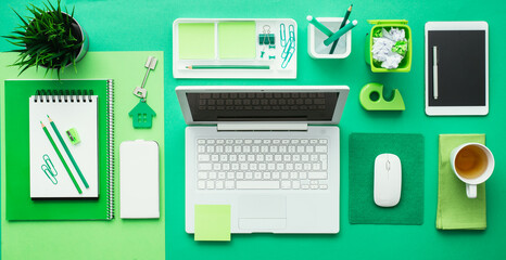 Green creative and eco-friendly desktop with laptop and office accessories, business and environmental care concept, flat lay © Designpics