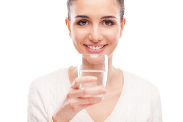 Smiling young woman with a glass drinking water, purity and wellbeing concept