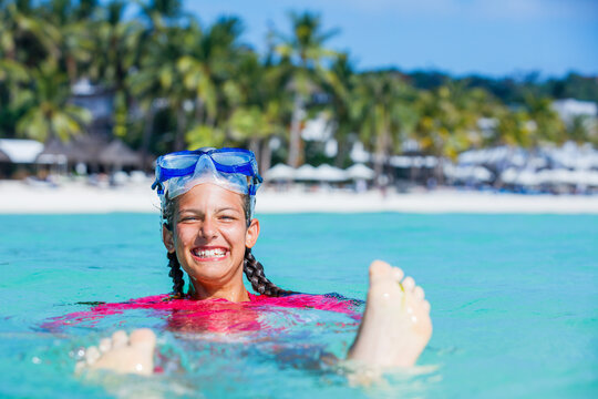Photo of happy snorkeling girl in pink swimwear