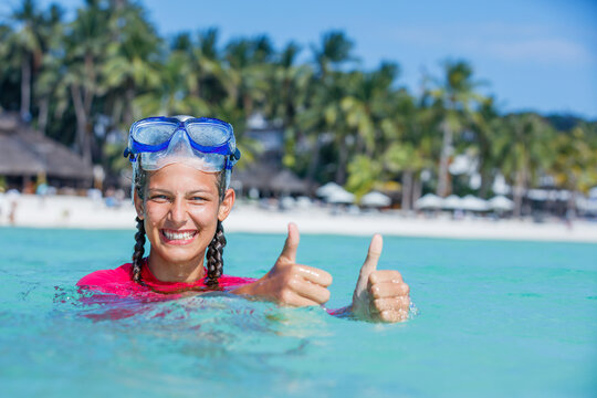 Photo of happy snorkeling girl in pink swimwear