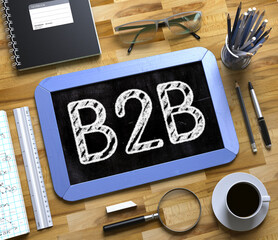 Blue Small Chalkboard with Handwritten Business Concept - B2B - on Office Desk and Other Office Supplies Around. Top View. B2B on Small Chalkboard. 3d Rendering.