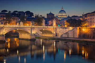 View of Vittorio Emanuele Bridge and the St. Peter's cathedral in Rome, Italy at night.