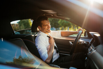 Young businessman driving a luxury car