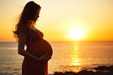 Fototapeta premium Pregnant woman holding her belly at beach with copy space