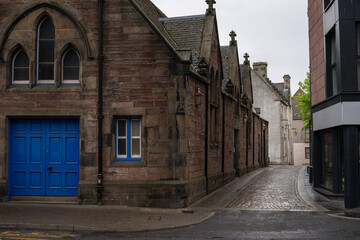 Fototapeta na wymiar 2023-06-11 A SIDE ALLEYWAY ALONG A OLD BRICK BUILDING WITH WET STREET IN INVERNESS SCOTLAND
