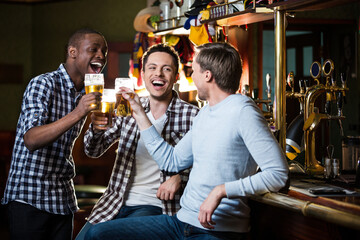 Smiling man with a beer indoors