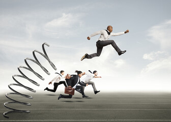 Businessman jumping on a spring during a race with opponents