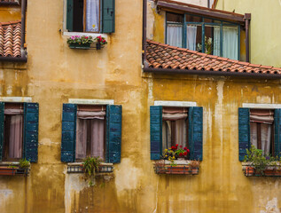 Vintage window on yellow cement wall. old town in Venice. Stained glass window of a house near the canal in Venice, Italy.