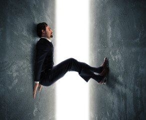 Businessman man trapped between two walls strives to push