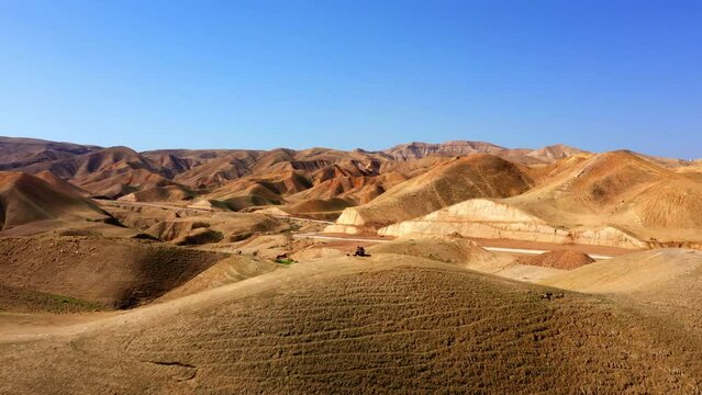 Aerial Backward Shot Of Tourists On Hill Near Road And Mountain Ranges - Nabi Musa, Israel