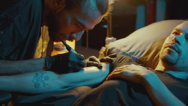 Male Tattoo Artist Using The Handpoke Method - close up