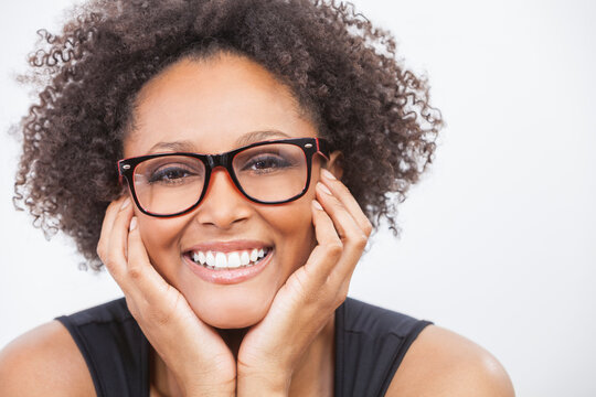 A beautiful intelligent mixed race African American girl or young woman with perfect teeth happy laughing wearing geek glasses