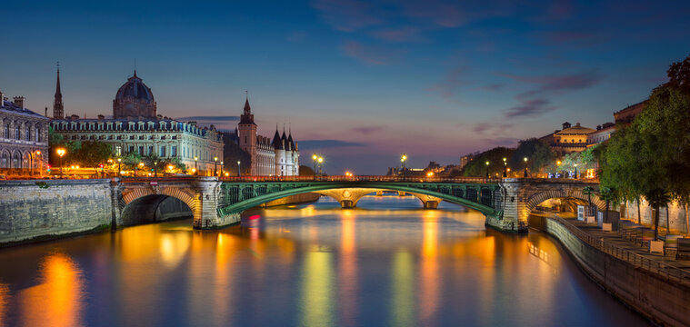 Panoramic image of Paris riverside during twilight blue hour.