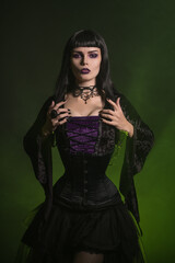 Beautiful Halloween witch dressed in a corset and velvet blouse, studio shot