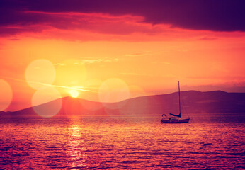 Beautiful Seascape with Sailing Yacht in Calm Bay at Sunset. Quiet Sea. Beautiful Bokeh. Toned and...