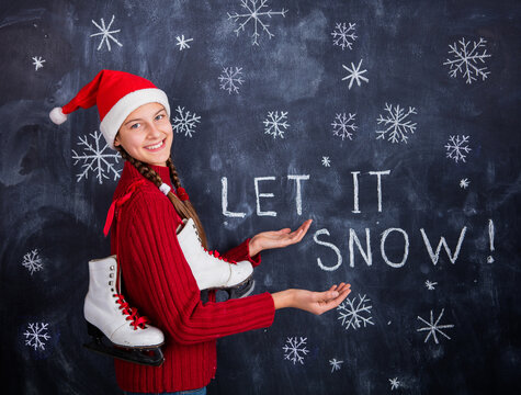Christmas theme - lets it snow. Happy cute girl in studio in santa hat