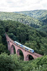 old arch Bridge railway viaduct between hills in the green Forest Germany trees - 622153376