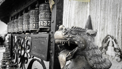 A dragon statue with Tibetan prayers in a metallic structure in black and white image