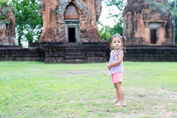 Happy young girl running at the park during summer in nature.