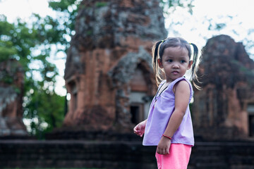 A young Southeast Asian girl walks to study the history of the ancient Khmer castle Khu Suan Taeng...