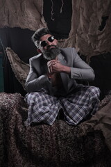 Portrait of a happy South Indian bearded man wearing suit and goggles. Stylish man in different poses and expressions. Coat and pant.