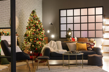Interior of dark living room with sofa, armchair, fireplace, Christmas tree and glowing lights