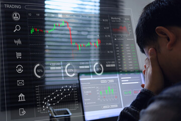 The investor sat with analytic dashboard and his head down, showing disappoint because of losses on the stock exchange market. Investment is risky, please study before making a decision.