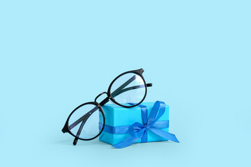 Gift box with eyeglasses on blue background