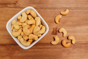 Cashew nuts in the bowl on the wooden table