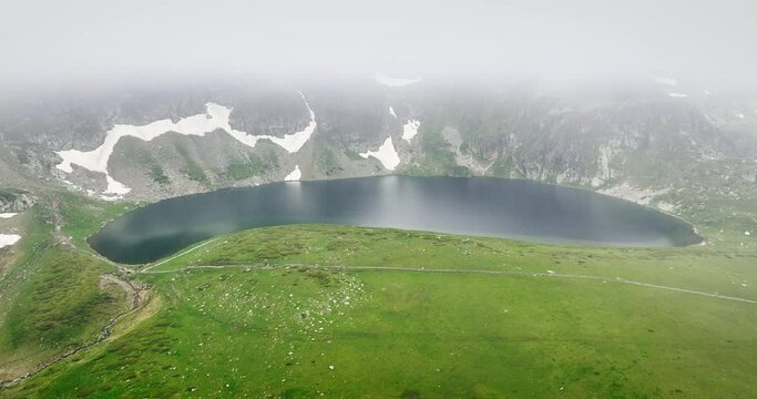 Mountain lake in fog nature of Rila mountains Bulgaria, Babreka pond, 4K video 
