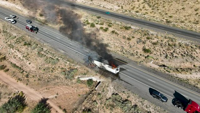 Aerial semi truck highway fire meat burning. Interstate highway in desert of Arizona and Nevada. Transporting fresh meat. Fire and smoke destroys cargo and HAZMAT pollution.