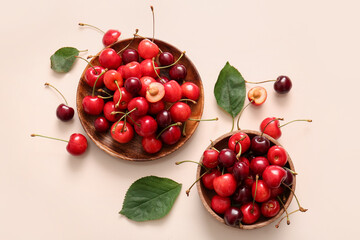 Obraz na płótnie Canvas Bowls with sweet cherries on beige background