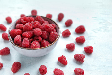 Bowl with fresh raspberry on light background, closeup