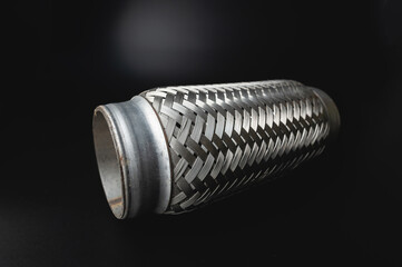 Flexible tube connection to the car exhaust system on black background.