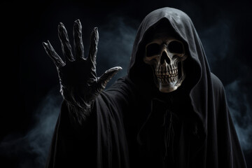 Fototapeta na wymiar Creepy halloween grim reaper figure wearing a black rope against a dark background
