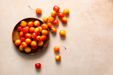 Plate with sweet yellow cherries on white background