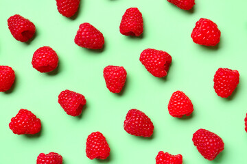 Many fresh raspberries on green background